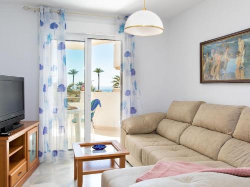 een woonkamer met een bank en een tv bij Apartment Cala Verde II - AMU615 by Interhome in Salobreña
