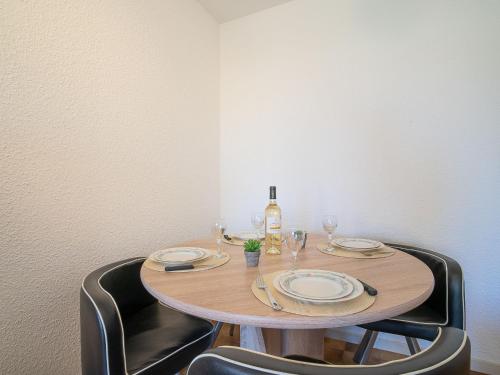 - une table avec 2 chaises et une bouteille de vin dans l'établissement Apartment Les Bastides de Grand Stade-9 by Interhome, à Saint Cyprien Plage