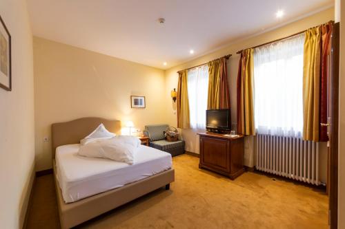une chambre d'hôtel avec un lit et une télévision dans l'établissement Hotel Bemelmans-Post, à Collalbo