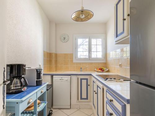 Elle comprend une petite cuisine avec des placards bleus et une fenêtre. dans l'établissement Apartment Beau Rivage by Interhome, à Carqueiranne