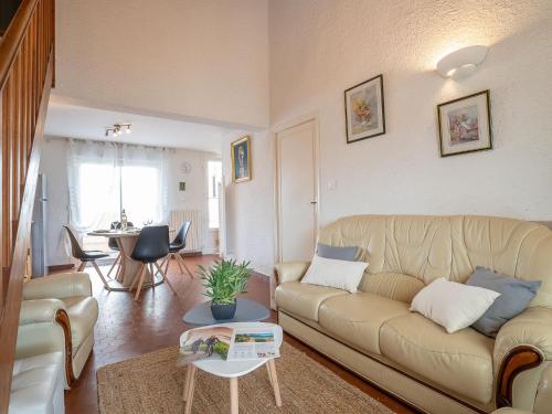 a living room with a couch and a table at Holiday Home Les Villas de l'Aygual-4 by Interhome in Saint Cyprien Plage