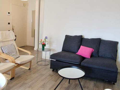 - un salon avec un canapé bleu et un oreiller rose dans l'établissement Apartment Les Jardins du Yacht Club by Interhome, à Deauville