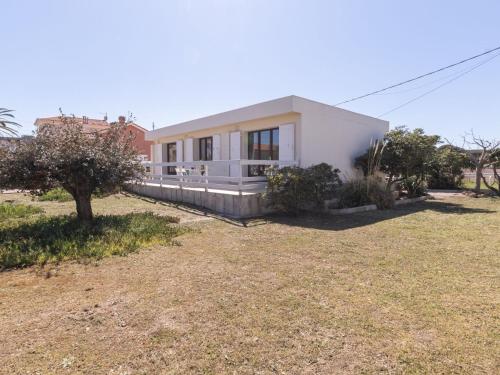 une maison blanche avec une cour devant elle dans l'établissement Villa Les Pesquiers by Interhome, à Hyères