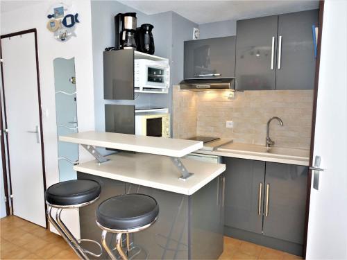 - une cuisine avec un comptoir et deux tabourets dans l'établissement Apartment Les Maisons sur la Plage-9 by Interhome, à Narbonne-Plage