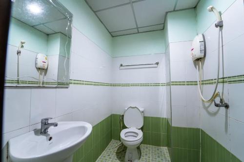 y baño con lavabo, aseo y espejo. en OYO 75377 Check In House, en Suratthani