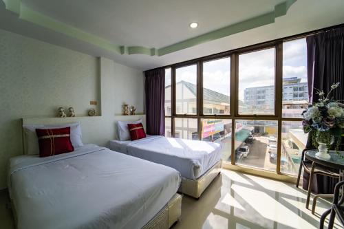 2 camas en una habitación con ventana grande en OYO 75377 Check In House, en Suratthani