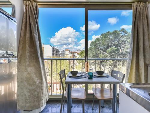 une salle à manger avec une table et des chaises et une grande fenêtre dans l'établissement Apartment La Brise by Interhome, à Cannes