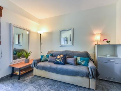 un salon avec un canapé bleu avec des oreillers dans l'établissement Apartment La Brise by Interhome, à Cannes