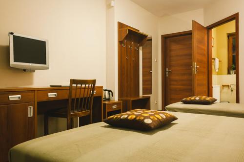 sypialnia z biurkiem i łóżkiem z poduszką w obiekcie Apartamenty na Wydmie w Gąskach
