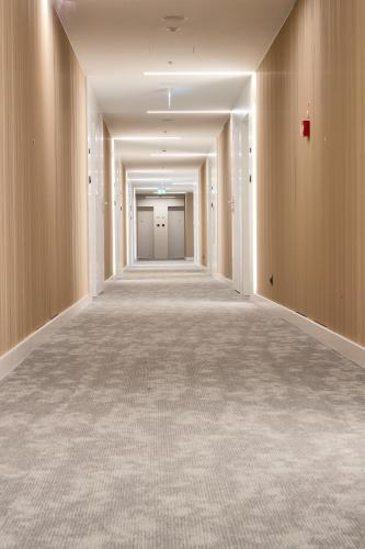 an empty corridor in a building with white walls at PINEA Apartments Pobierowo z niesamowitym widokiem na morze oraz jacuzzi w wybranych apartamentach in Pobierowo