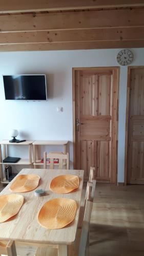 a wooden table with four chairs and a kitchen with wooden ceilings at Małe Kaszuby in Słajszewo