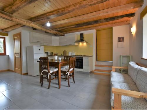 a kitchen and dining room with a table and chairs at Chalet Rustico Rebustella by Interhome in Civo