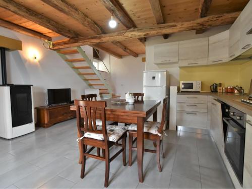 a kitchen with a table and chairs and a refrigerator at Chalet Rustico Rebustella by Interhome in Civo