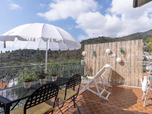 un patio con mesa y sombrilla en Villa Casetta in collina by Interhome, en San Remo