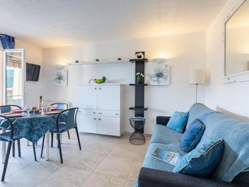 un salon avec un canapé bleu et une table dans l'établissement Apartment La Nuit de Mai-5 by Interhome, à Saint-Aygulf