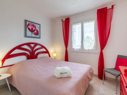 Schlafzimmer mit einem Bett und einem Fenster mit roten Vorhängen in der Unterkunft Apartment La Nuit de Mai-5 by Interhome in Saint-Aygulf