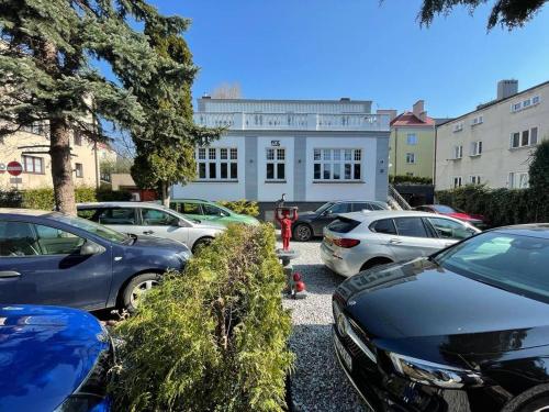 a parking lot with cars parked in front of a building at Willa 1936 , Parking in Toruń