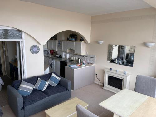 a living room with a couch and a kitchen at Redcliffe Apartments Flat 7A in Swansea