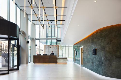 a lobby with a person sitting at a desk in a building at Hyatt House Manchester - Aparthotel in Manchester