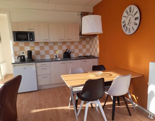 een keuken en eetkamer met een houten tafel en stoelen bij Appartement Kooiker in Buren