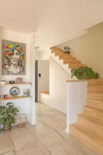 a living room with stairs and a painting of a woman at Villa Luxe&Nature, 10 mins de Montpellier, 6 personnes in Saint-Jean-de-Védas
