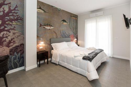 a bedroom with a bed and a wall mural at Malù Suites in Messina