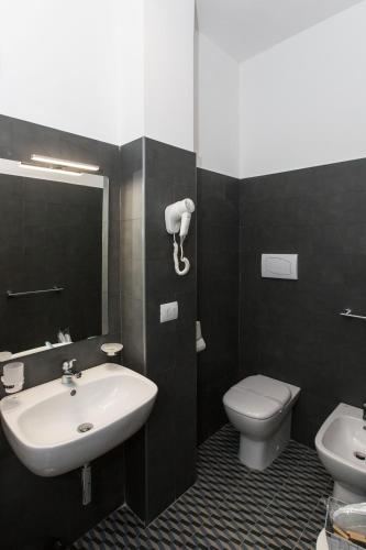 a bathroom with a sink and a toilet at Malù Suites in Messina