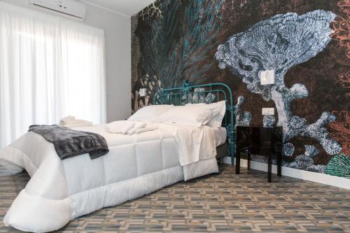 a bedroom with a bed and a painting on the wall at Malù Suites in Messina
