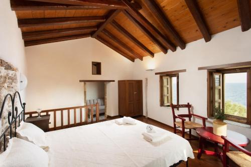 una camera con un grande letto bianco di Rodi House a Monemvasía