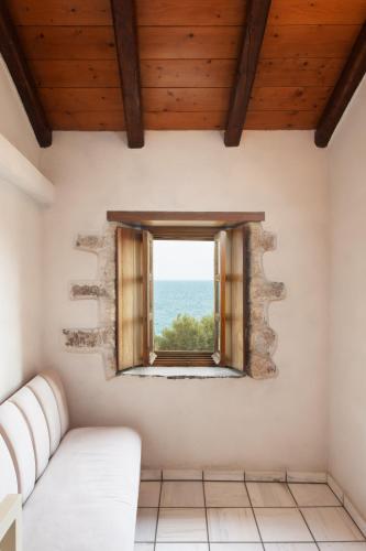 a living room with a couch and a window at Rodi House in Monemvasia