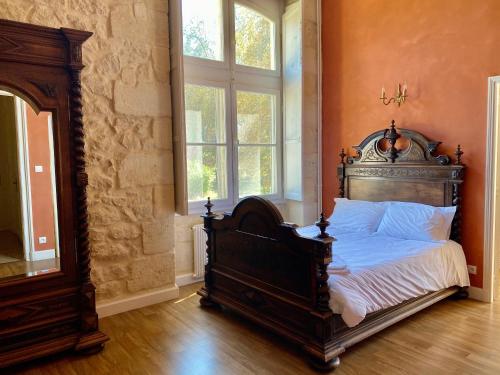 a bed in a room with a large window at Château Borgeat de Lagrange - privatisation in Blaye