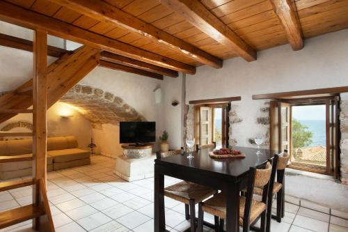 cocina y sala de estar con mesa y sillas en Rodi House, en Monemvasia