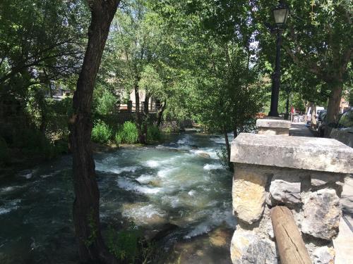 a river with a tree and a street light next to it at Apartamento del Río in Pinos Genil