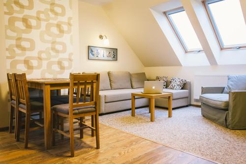 a living room with a couch and a table with a laptop at Apartamenty na Wydmie in Gąski