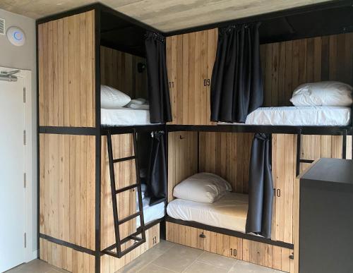 a bunk bed with three beds in a room at Zarautz Surf House in Zarautz