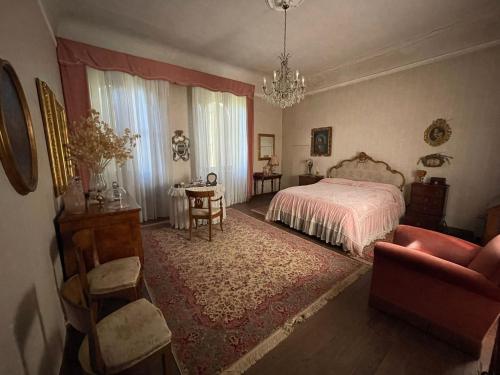 um quarto com uma cama, uma cadeira e uma mesa em CASA LA TORRE un castello alle porte di Firenze em Florença