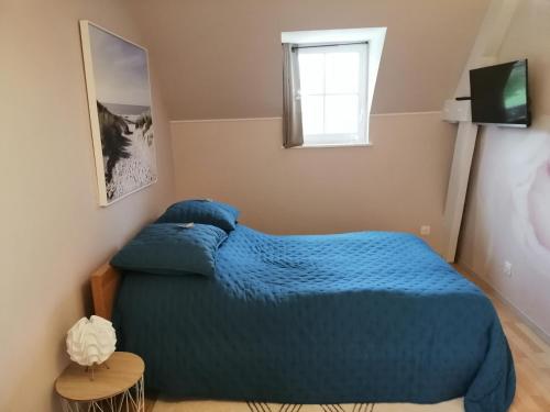 Le Torcopel في Grangues: غرفة نوم بسرير ازرق ونافذة