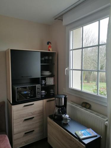 un salon avec un four micro-ondes et une grande fenêtre dans l'établissement Le Torcopel, à Grangues