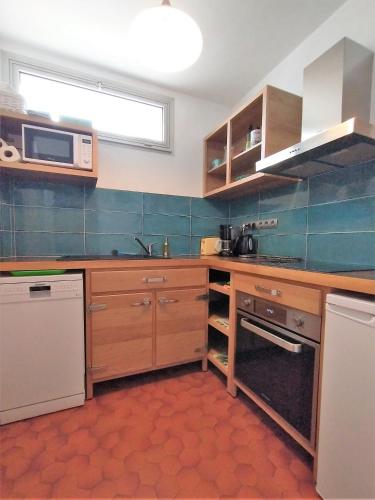 - une cuisine avec des placards en bois et un four micro-ondes dans l'établissement TY TREZ Magnifique vue mer à Bénodet 10 Avenue de la Plage Résidence 