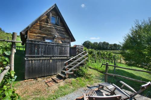 an old wooden house with a bunch of chairs in front of it at Kellerstöckl Knusperhäuschen in Eltendorf