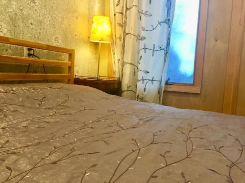 a bedroom with a bed and a window and a lamp at Cozy multi-leveled apartment! in Rosebank