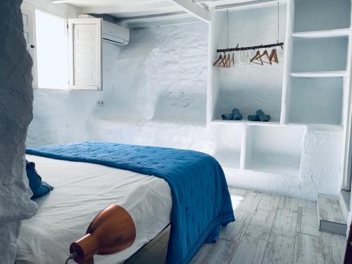 a bedroom with a bed with a blue blanket on it at La Careza De Mijas - Adults Only in Mijas