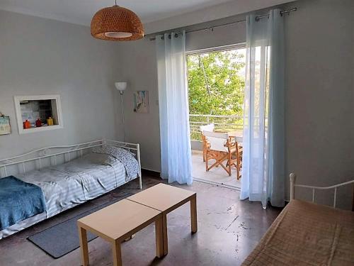 Un dormitorio con una cama y una mesa y una ventana. en Apartments MARINA, en Porto Rafti