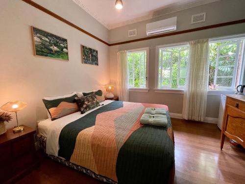 um quarto com uma cama e duas janelas em Babinda Quarters em Babinda