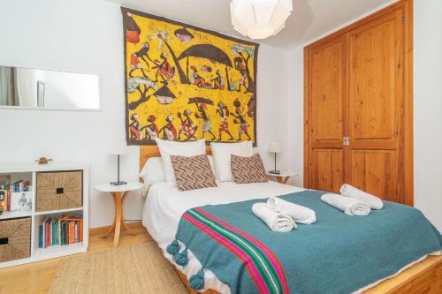 a bedroom with a bed with a painting on the wall at Els Àngels in Ses Salines