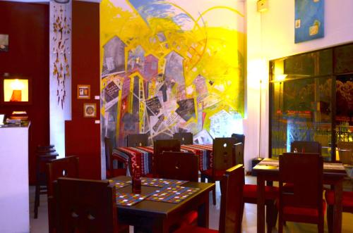 a restaurant with tables and chairs and a painting on the wall at Hotel Pinares Plaza in Pereira