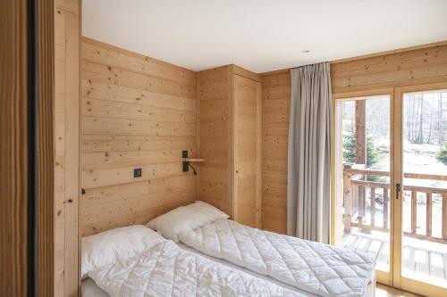 Cama en habitación de madera con ventana en Polaris 1 005 - LUXE & SKI LIFT apartment 6 pers, en Zinal