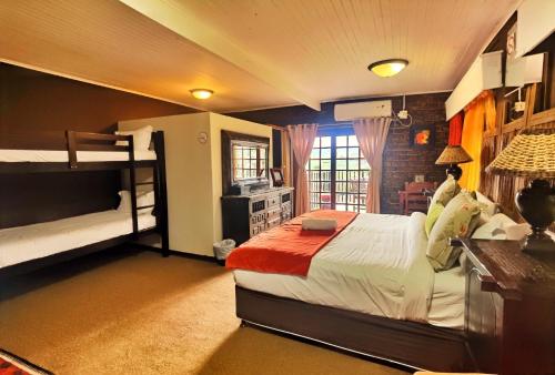 a bedroom with two bunk beds and a desk at Camelot Guesthouse in Newcastle