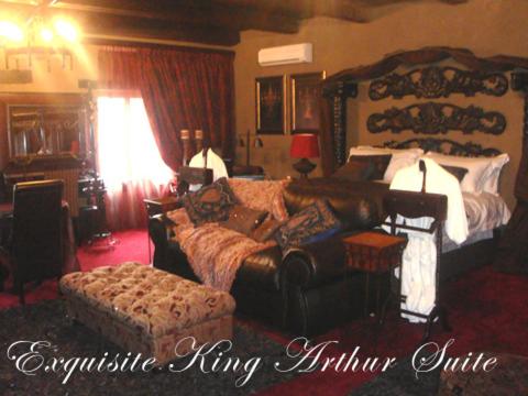 a living room with a bed and a couch at Camelot Guesthouse in Newcastle