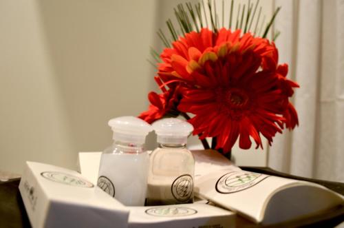 a vase with a red flower and two bottles of milk at Hotel Pinares Plaza in Pereira
